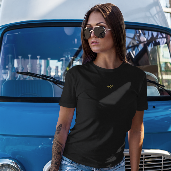 Female model wearing white Gordz Grayson Women’s Signature Logo Tee with bold black chest print – fitted streetwear style symbolising confidence and empowerment.